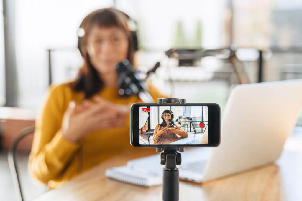 Woman vlogger speaking on smartphone camera while shooting live